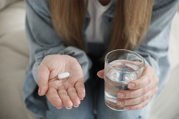 A woman taking a pill as part of her medical abortion