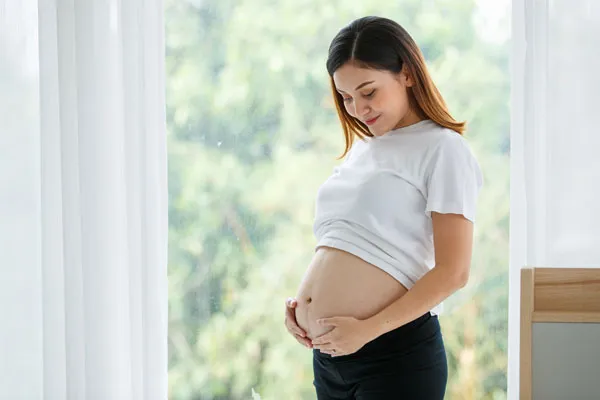 A pregnant woman holding her belly